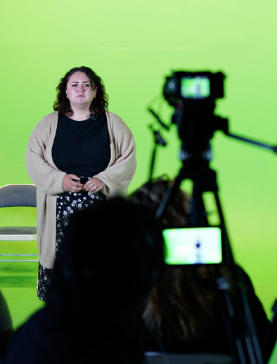 a woman standing in front of a green screen videographer in los angeles